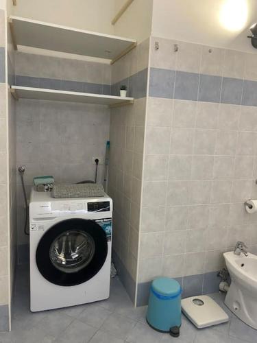 a washing machine in a bathroom with a toilet at Appartamento Giardino e Parcheggio in Borgio Verezzi