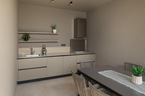 a kitchen with a sink and a table with chairs at Design Villa Istar in Bale