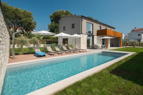 a swimming pool in front of a house at Design Villa Istar in Bale
