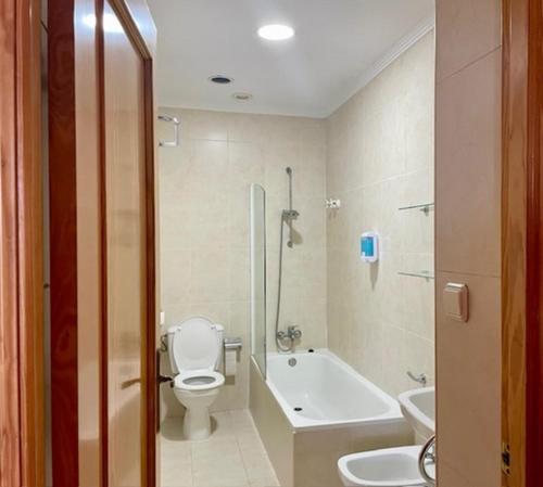łazienka z toaletą, wanną i umywalką w obiekcie Hotel Torre San Juan w mieście San Juan de Alicante