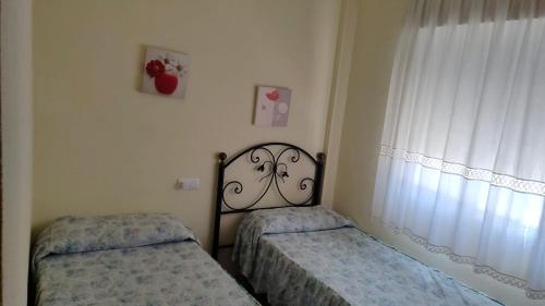 a bedroom with two beds next to a window at Costa Portil - Arroyo de la Plata 5 in El Portil