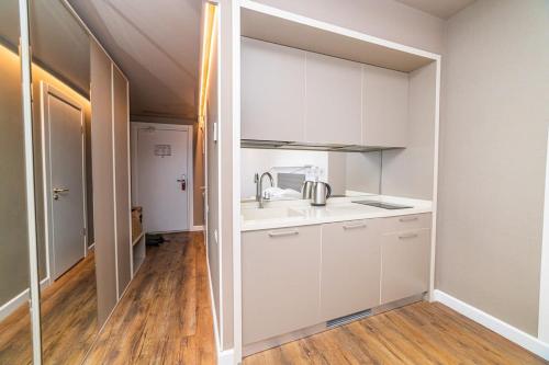 a kitchen with white cabinets and a sink at Stylish Apt In Alliance Palace in Batumi