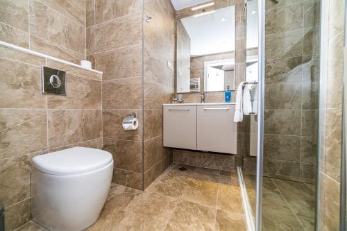 a bathroom with a toilet and a shower at Stylish Apt In Alliance Palace in Batumi