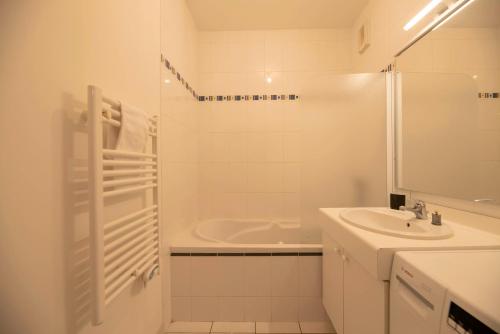 une salle de bain blanche avec un lavabo et une douche dans l'établissement La Vilaine, à Rennes