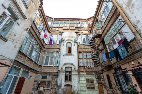 an old building with clothes drying on a balcony at Opera House 2BR Apt with Tbilisi Charm - By Wehost in Tbilisi City