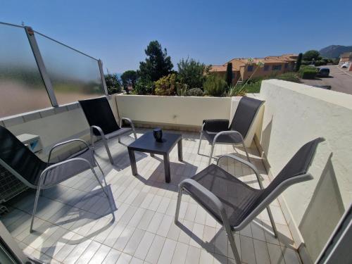 un groupe de chaises et une table sur une terrasse dans l'établissement Plage à pieds, à Théoule-sur-Mer