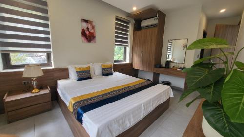 a bedroom with a bed and a plant in it at Lotus Premium Lodge - Lotus Group Tours in Ha Giang