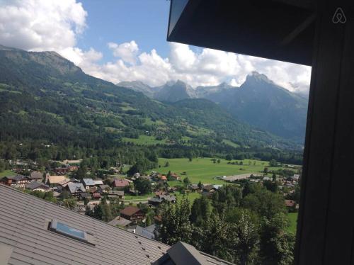 vista su un villaggio in una valle con montagne di Appartement Tout Confort a Morillon