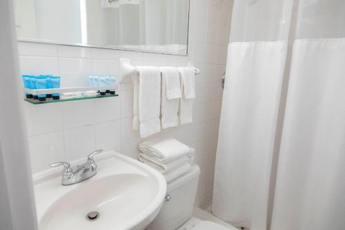 a bathroom with a sink and a toilet and a mirror at Beach Place Hotel in Miami Beach