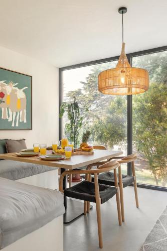 a dining room with a table and a large window at Sobral Serenity Villa in Amoreira