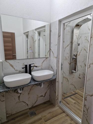 a bathroom with two sinks and a mirror at Apartmani & Auto kamp GAJ in Gacko
