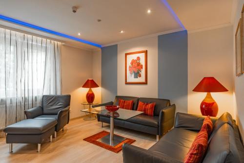 a living room with a couch and a table at Parkhotel Crombach in Rosenheim