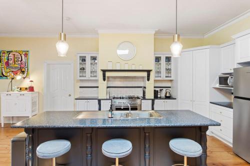 a kitchen with a large island with blue stools at 4-Bed 3-Bath Sunset Haven in Sunset Strip