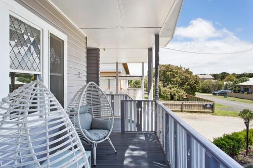 a porch with a blue chair and a swing at 4-Bed 3-Bath Sunset Haven in Sunset Strip
