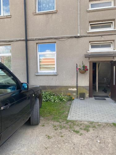 a car parked in front of a house at Apartamentai Rusnės centre Neringos g 6 in Rusnė