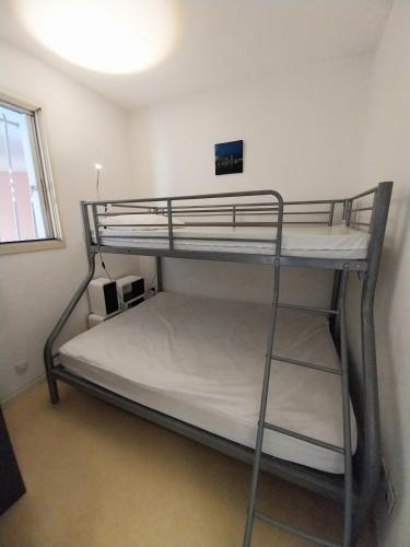une chambre avec deux lits superposés dans une pièce dans l'établissement quartier port de peche et plaisance residence avec piscine, à Sète