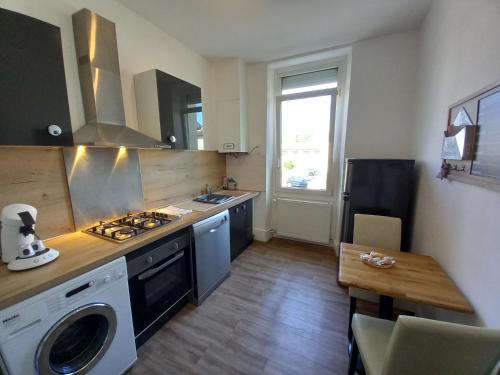 Il comprend une cuisine équipée d'une cuisinière, d'un évier et d'une table. dans l'établissement Appartement T3 en duplex Proche Gare sncf avec Parking à Montélimar, à Montélimar