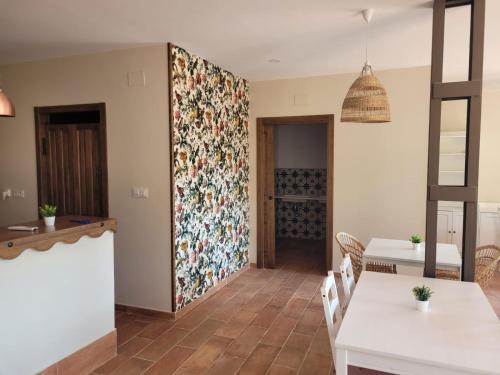 a dining room with a floral accent wall at Alojamientos Rurales Hurdes Altas - La Antigua Guarderia in Casares de las Hurdes