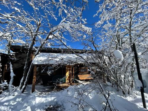 a cabin covered in snow in the woods at Refugio Nativo in Nevados de Chillan