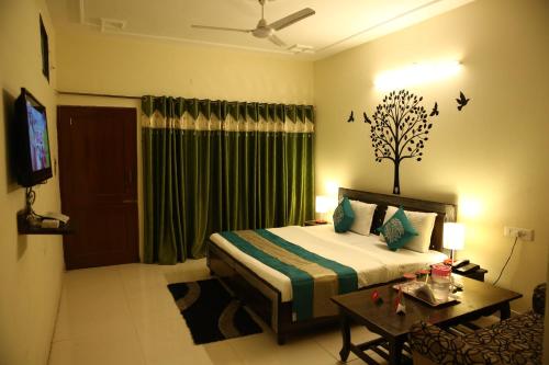a bedroom with a bed and a table and a television at Hotel the diamond Ring in Chandīgarh