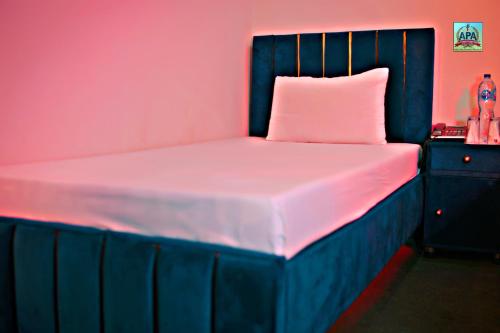 a bed in a room with pink and blue at Quick continental Hotel - Jail Road in Lahore
