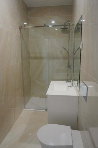a bathroom with a shower and a toilet and a sink at Alojamento Fortaleza in Valença