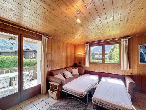 - un salon avec un canapé, un lit et des fenêtres dans l'établissement Chalet de standing 4/6 pers, prox remontées, parking, non-fumeur - FR-1-507-32, à Chamonix-Mont-Blanc