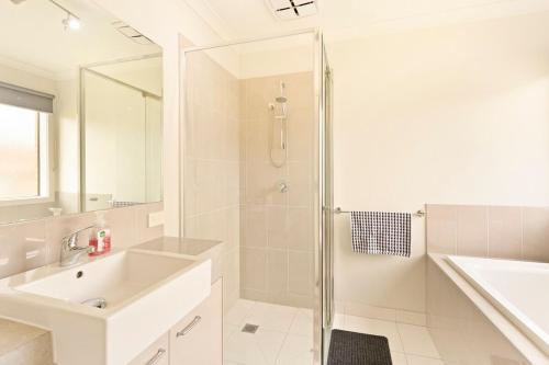 Family w Large Pool & Game Garage Wlk to Beach في كاوز: حمام أبيض مع حوض ودش