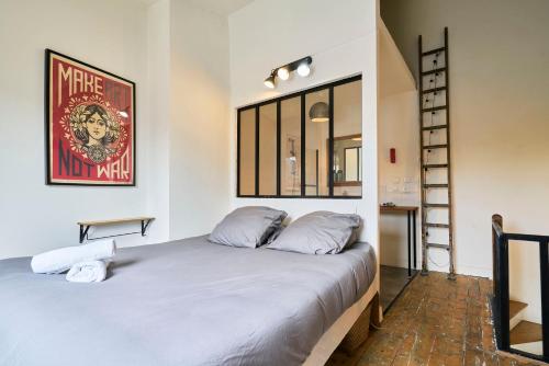 - une chambre avec un lit dans une pièce avec une échelle dans l'établissement Le Refuge - Les Demeures d'Adrien, à Lille