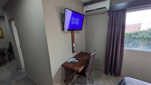 a room with a desk and a tv on a wall at Tres Arroyos Studio in Tres Arroyos