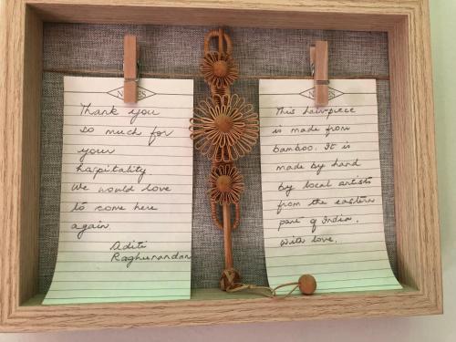 a note book with flowers on it in a wooden frame at Deluxe Apartment In City Center in Tirana