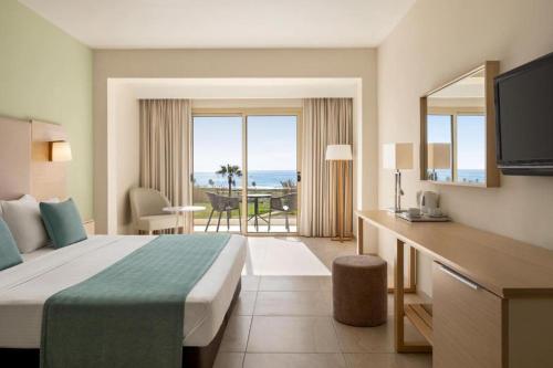 a hotel room with a bed and a view of the ocean at Freij Hotel & Resort in Ayia Napa