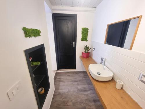 baño con lavabo y puerta negra en L'altra Vinedda - Proppro SRL - Milazzo, en Milazzo