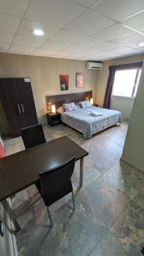 a bedroom with a bed and a table and a desk at Tres Arroyos Studio in Tres Arroyos