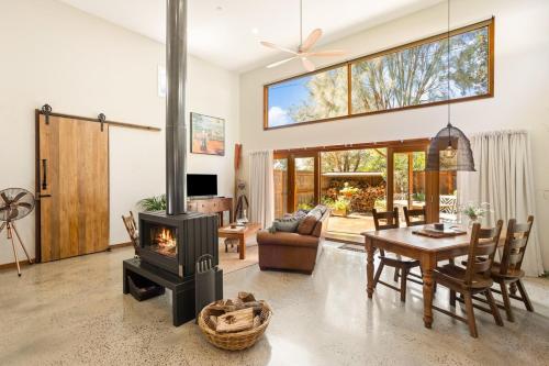 a living room with a table and a fireplace at The Ancient Mariner Retreat in Cape Woolamai