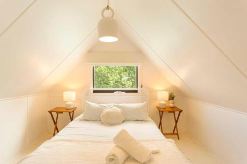 a bedroom with a white bed with a window at Kilara Cottage 3-Bed 2-Bath in Cowes