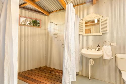 a bathroom with a shower curtain and a sink at Kilara Cottage 3-Bed 2-Bath in Cowes