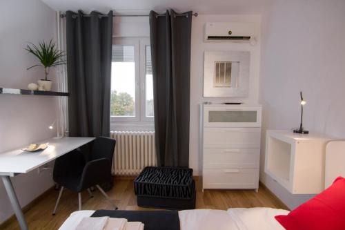 a small room with a desk and a table and a window at Apartment Madera in Belgrade