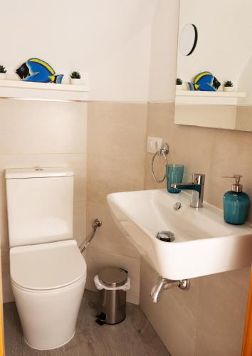 a bathroom with a white toilet and a sink at Casa la Buganvilla-Mojácar Playa in Mojácar