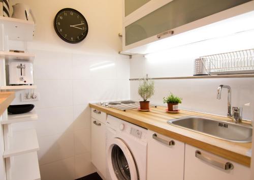 a kitchen with a washing machine and a clock on the wall at Apartment Madera in Belgrade