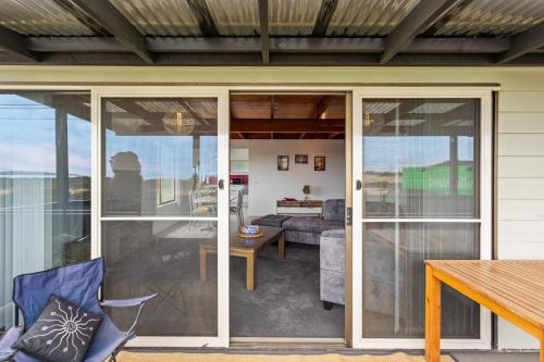 a conservatory with sliding glass doors on a house at 2-Person Surf Beach Studio App in Surf Beach