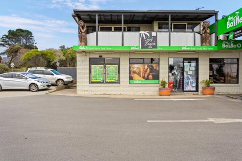 a store front with cars parked in a parking lot at 2-Person Surf Beach Studio App in Surf Beach