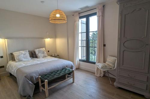 une chambre avec un lit et une grande fenêtre dans l'établissement Mas d exception au cœur des Alpilles, à Fontvieille
