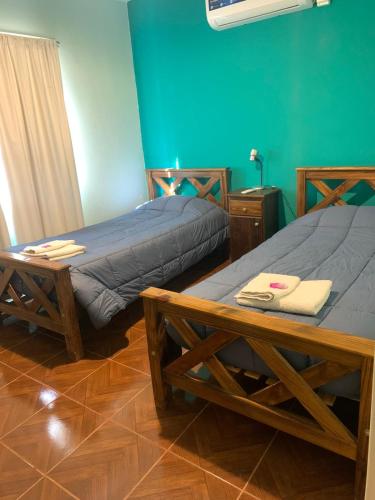two beds in a room with green walls and a table at DEPARTAMENTO CAROLA in San Juan
