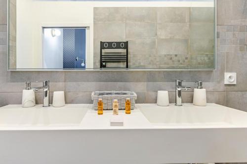 une salle de bain avec deux lavabos et un miroir dans l'établissement Newly renovated apt near La Madeleine, à Paris