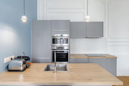 - une cuisine avec des appareils blancs et un comptoir en bois dans l'établissement Newly renovated apt near La Madeleine, à Paris