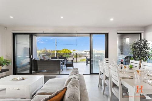 Una sala de estar con un sofá y una mesa con sillas. en Luxurious Home Close to The Beach, en Surf Beach