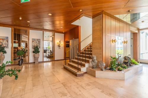 a lobby with a staircase in a building at Parkhotel Crombach in Rosenheim