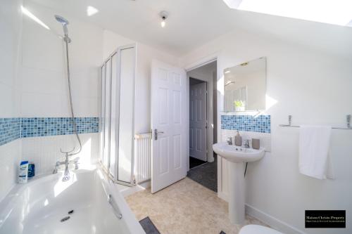 IwadeにあるReams Way 5Bedroom House Sleeps 13 in Kent with Wifi & Free Parking By Maison Christo Property Short Lets & Serviced Accommodationの浴槽と洗面台のある白いバスルーム