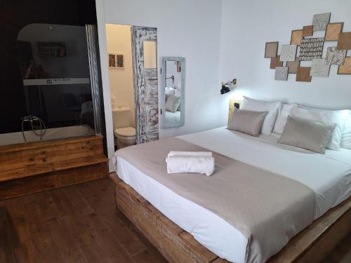 a bedroom with a large bed and a bath tub at Lovin Book Guesthouse in Óbidos